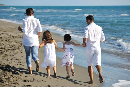 happy young family in white clothing have fun at vacations on beautiful beach 