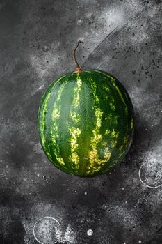 Whole fresh ripe watermelon set, on black dark stone table background