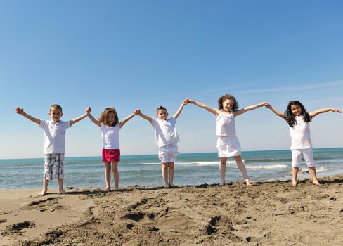 group of happy child on beach who have fun and play games