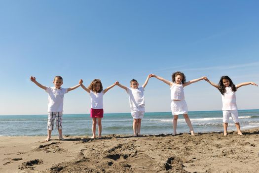 group of happy child on beach who have fun and play games