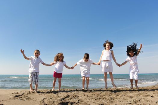 group of happy child on beach who have fun and play games