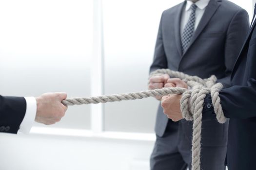 close up.businessman drags his business team by the rope .photo with copy space