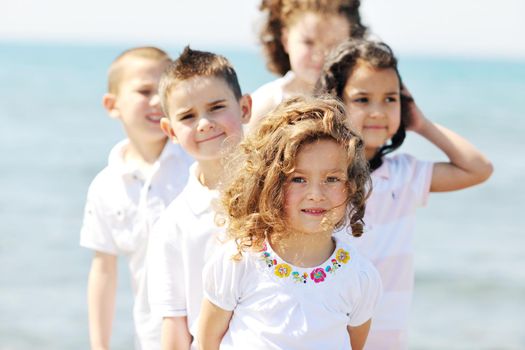 group of happy child on beach who have fun and play games