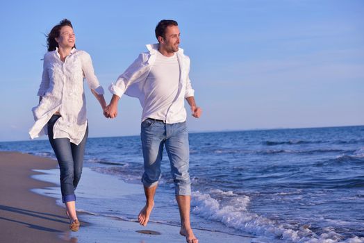 happy young romantic couple in love have fun on beautiful beach at beautiful summer day