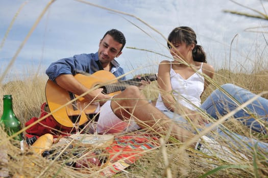 happy young couple enjoying  picnic on the countryside in the field  and have good time