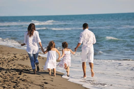 happy young family in white clothing have fun at vacations on beautiful beach 