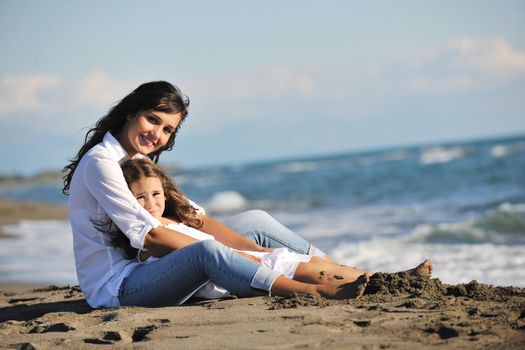 family portrait of young beautiful mom and daughter on beach