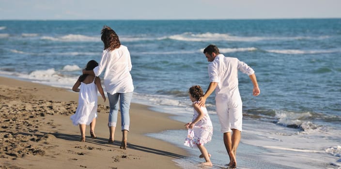 happy young family in white clothing have fun at vacations on beautiful beach 