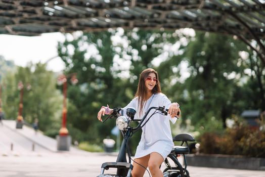 Young beautiful woman and an electric scooter, modern girl, new generation, electric transport, ecological transport