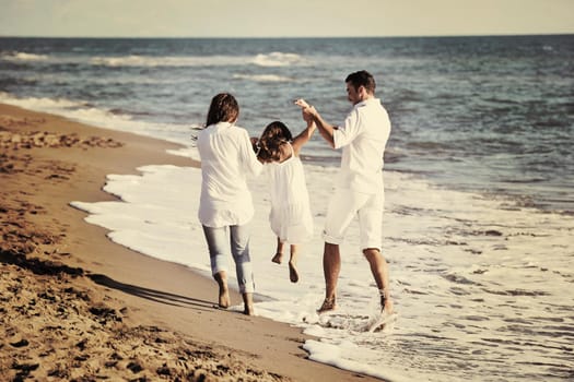 happy young family in white clothing have fun at vacations on beautiful beach 