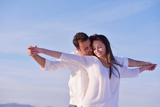 happy young romantic couple in love have fun on beautiful beach at beautiful summer day