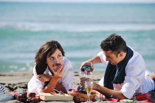 happy young couple enjoying  picnic on the beach and have good time on summer vacations