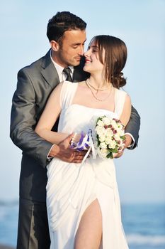 happy just married young couple celebrating and have fun at beautiful beach sunset