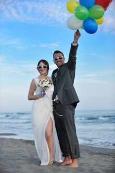 happy just married young couple celebrating and have fun at beautiful beach sunset