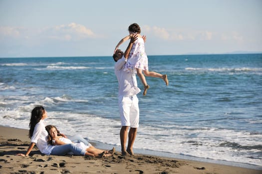 happy young family in white clothing have fun at vacations on beautiful beach