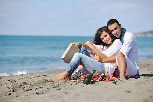 happy young couple enjoying  picnic on the beach and have good time on summer vacations