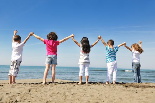 group of happy child on beach who have fun and play games