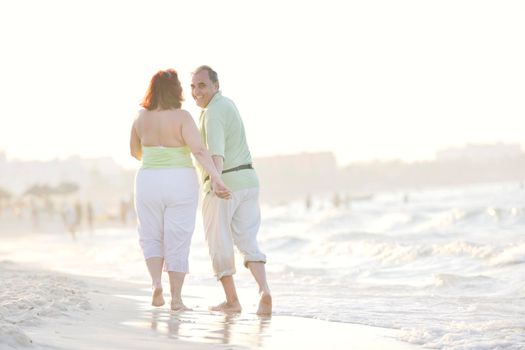 happy senior mature elderly people couple have romantic time on beach at sunset 