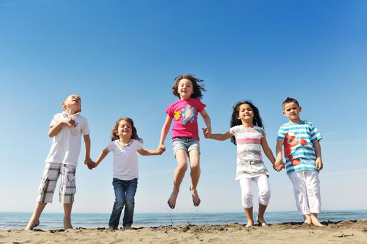 group of happy child on beach who have fun and play games