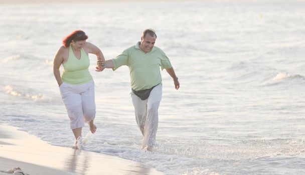 happy senior mature elderly people couple have romantic time on beach at sunset 