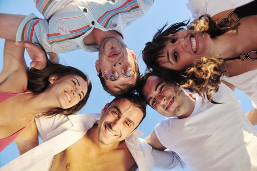 happy young friends group team huging have fun and celebrate  on the beach at the sunset