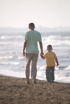 father and son walking on beach
