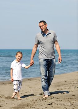 happy young  father and son have fun and enjoy time on beach at sunset and representing healthy family and support concept