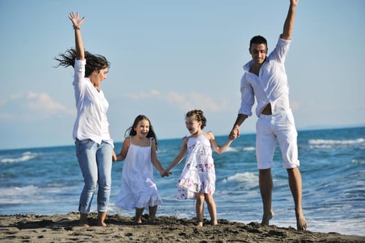 happy young family in white clothing have fun at vacations on beautiful beach 