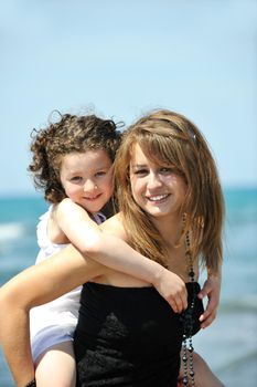 group portrait of happy childrens with young female  teacher on beach