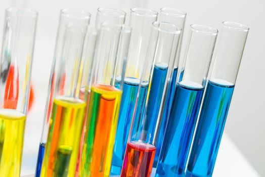 Science laboratory research and development. Close up test tubes with colorful substance on white background. Chemical manufacture concept with glass equipment. Modern biotechnology industry.