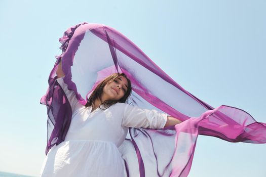 beautiful young woman on beach with scarf relax smile and have fun