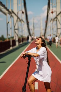 Young beautiful woman and an electric scooter, modern girl, new generation, electric transport, ecological transport