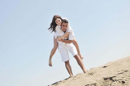 happy young couple have fun and romantic moments on beach at summer season and representing happynes and travel concept