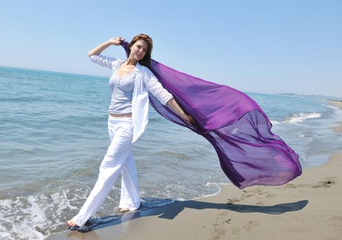 happy young woman relax on beautiful  beach at fresh summer morning and enjoy first ray of sun