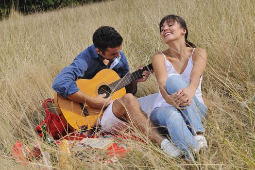 happy young couple enjoying  picnic on the countryside in the field  and have good time