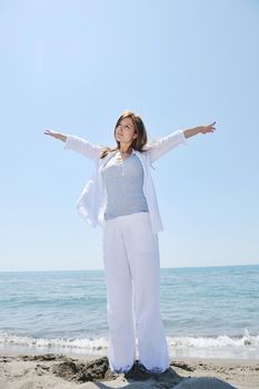 happy young woman relax on beautiful  beach at fresh summer morning and enjoy first ray of sun