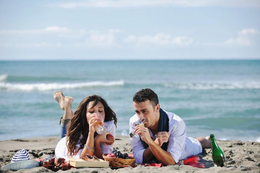 happy young couple enjoying  picnic on the beach and have good time on summer vacations