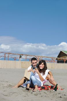 happy young couple enjoying  picnic on the beach and have good time on summer vacations