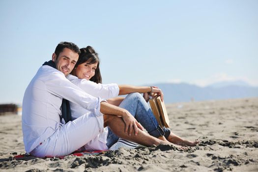 happy young couple enjoying  picnic on the beach and have good time on summer vacations