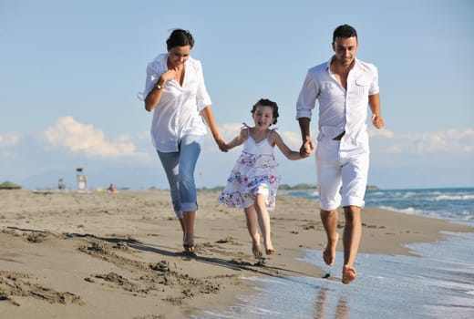 happy young family in white clothing have fun at vacations on beautiful beach