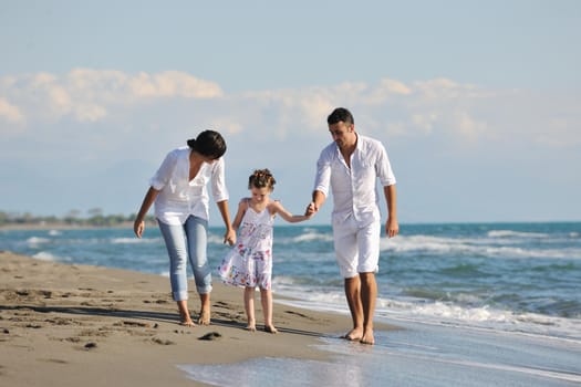 happy young family in white clothing have fun at vacations on beautiful beach 
