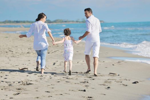 happy young family in white clothing have fun at vacations on beautiful beach