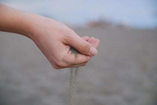 fine sand leaking trought woman hands