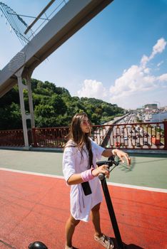 Young beautiful woman and an electric scooter, modern girl, new generation, electric transport, ecological transport