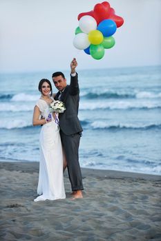 happy just married young couple celebrating and have fun at beautiful beach sunset