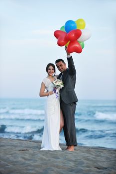 happy just married young couple celebrating and have fun at beautiful beach sunset