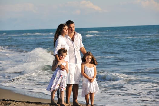 happy young family in white clothing have fun at vacations on beautiful beach 