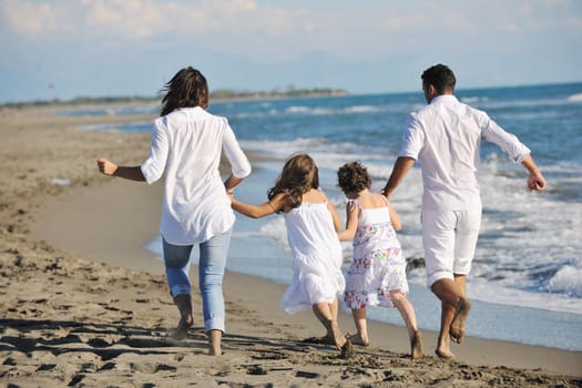 happy young family in white clothing have fun at vacations on beautiful beach 