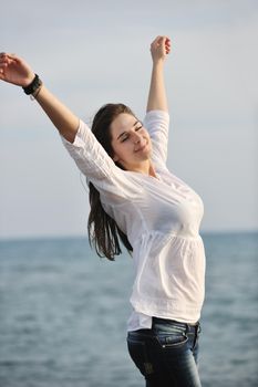 happy young woman relax on beautiful  beach at fresh summer morning and enjoy first ray of sun