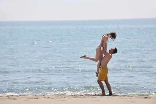 happy young couple have fun and romantic moments on beach at summer season and representing happynes and travel concept